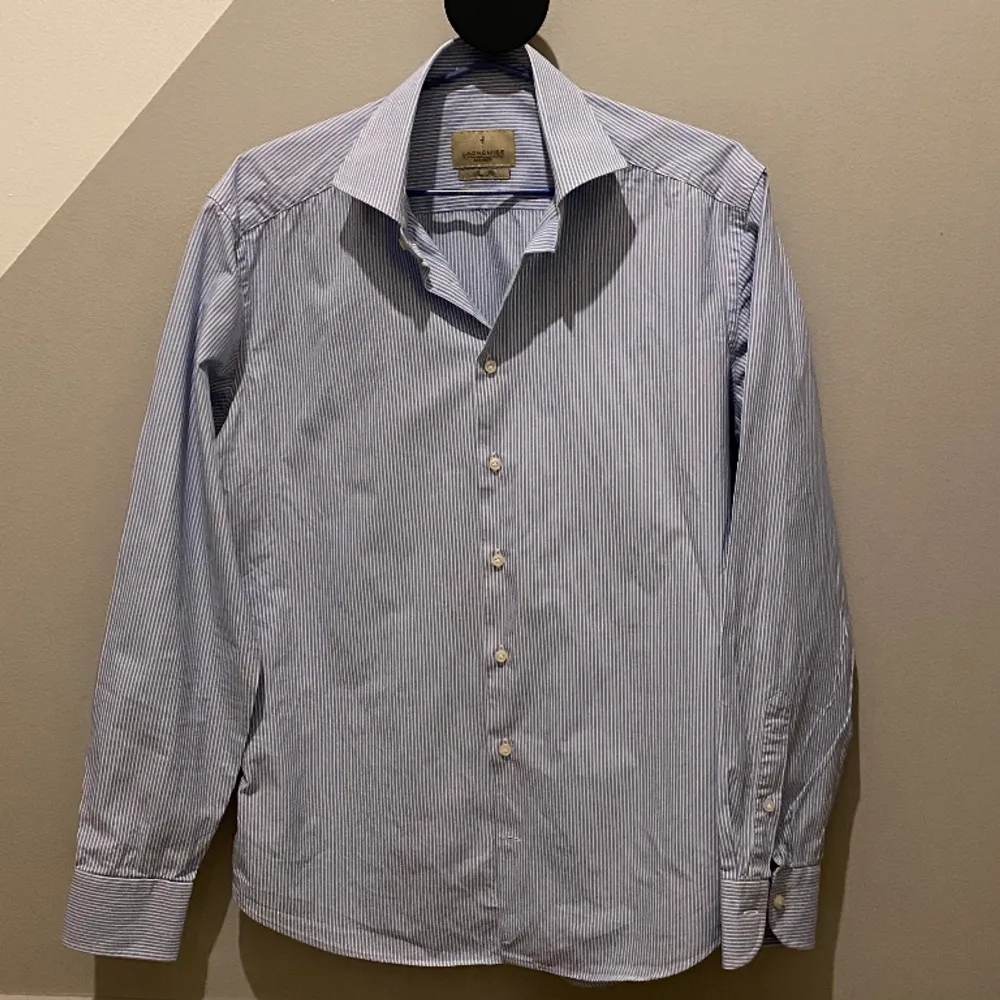En stilren skjorta från Lachemise i en snygg ljusblå randig färg. Skjortan är i bra skick. Alla knappar är kvar! Slim fit. 100% Bomull  Hör av er vid frågor eller funderingar! . Skjortor.