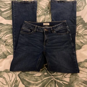Blå Bootcut jeans - Säljer dessa blå Bootcut jeans från Lindex i storlek 158. De har ganska mjukt material och har slitits sönder lite i botten på byxbenen💞
