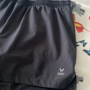 Träningsshorts med ett extra lager! - Dessa träningsshorts har ett par tajtare shorts under vilket gör shortsen mycket mer bekvämare. Så bra! Storleken är 36. Det originala priset är ca 250 men dessa säljs för 120kr vilket är super av den anledningen att de inte är särskilt slitna!