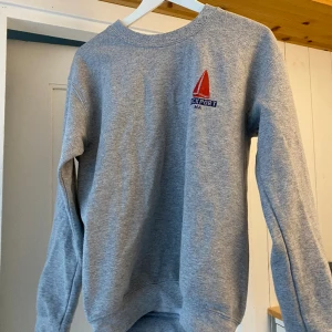 Sweatshirt grå - Mysig sweatshirt från Gildan! Lite seglarinspererat motiv på ryggen!! Superfin men använder den inte så mycket så hoppas den kommer passa bättre hos någon annan😊