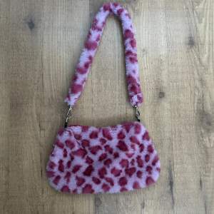 En rosa, fluffig handväska i leopardmönster. Knappt använd så i väldigt bra skick. Köparen står för frakt🌟