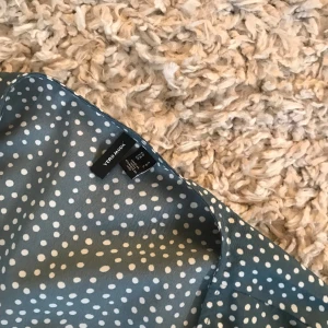 Klänning med volang  - Strl L grön med vita prickar 