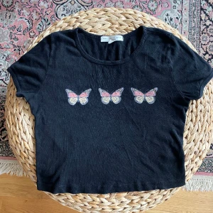 Black butterfly crop top y2k - Svart crop top i trikåmaterial med tre fjärilar på 🦋🦋🦋 I gott men använts skick. Storlek S, sitter som en S/M. Köpt i Los Angeles.