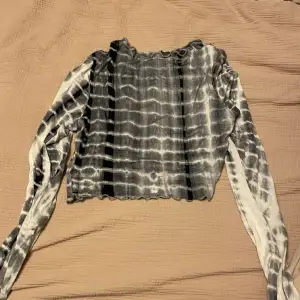 En croppad långärmad tröja i coolt mönster. Ganska tunt material. Knappt använd så inga fläckar eller liknande.