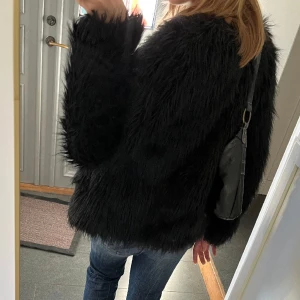 Svart pälsjacka  - Svart jacka i fuskpäls från Fushi. Kan inte hitta storlek men skulle säga M. Använd gärna köp nu!