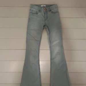Ljusblåa bootcut jeans - Ett par lågmidjade och bootcut ljusblåa jeans från Lindex i storlek 146! Säljer eftersom de är för små. 