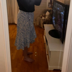 Blommig långkjol - Denna långkjol med volanger säljer jag nu🩷den är omlott med volanger. Har både knapp och kan knytas så den passar en själv. Vit blommigt tryck🌼Kan hämtas och skickas💫💫Kunden står för frakten