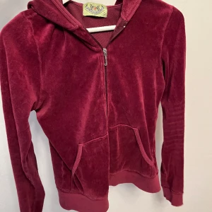 Juicy Couture hoodie  - Säljer en jätte ICONIC juicy couture hoodie som jag älskar ❤️ Den är i en mörk lila/vinröd färg som passar perfekt till allt möjligt. Det är den äldre versionen, det står storlek L men den passar mig som är en storlek xs/s. 