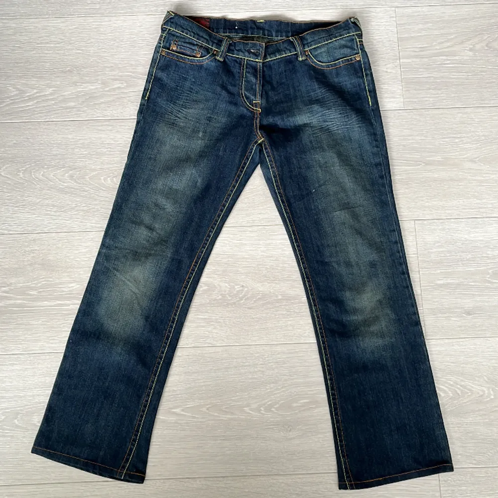 Dösnygga äkta Evisu jeans med coola detaljer! Jeansen är lågmidjade och har greenwash. De är i mycket bra skick med inga skador.  Raktöver midjan: 43cm the flare raktöver: 22cm ytterbenslängd: 95cm Kontakta vid frågor och intresse<3. Jeans & Byxor.