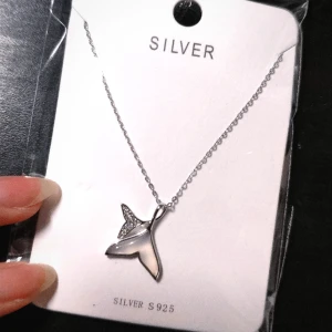 Trendig somrig halsband av sterlingsilver  - Sötaste halsbandet med två fenor 🌊🌊, en med Swarovskikristaller och en med en äkta vitjade pärla. Hela smycket är gjord av 100% sterlingsilver. Perfekt till stranden eller när man ska bada i ☀️en. ⛱️⛱️⛱️