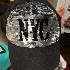 Keps  - Svart glittrig keps där det står NYC på. Du kanske inte vill ha denna? Men du kan ge bort den i present till nån som önskar sig denna! Väldigt billigt pris, köp!🩵