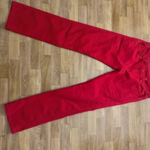 Röda lågmidjade jeans - Lågmidjade byxor i röd som är i mycket bra skick. Från vila och har snygga bakfickor. Bra längd på mig som är 173cm. 