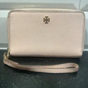 Stor rosa  plånbok från Tory Burch. Kan användas som mindre väska - du får med dig mobil, nycklar och läppstift utan problem! Använd men är i gott skick. 