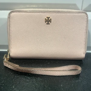 Tory Burch Perry zip wallet - Stor rosa  plånbok från Tory Burch. Kan användas som mindre väska - du får med dig mobil, nycklar och läppstift utan problem! Använd men är i gott skick. 