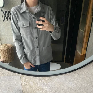 Overshirt  - Tjena säljer denna snygga overshirten från dressmann. I stl L och färgen grå. nyskick och vid minsta fundering är det bara att höra av sig🙌