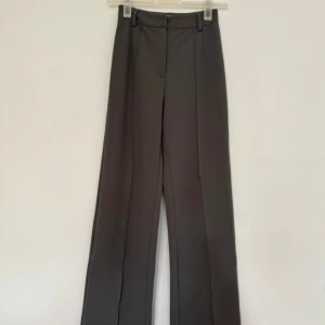 Figursydda kostymbyxor, storlek: 36 - Figursydda kostymbyxor med vida ben Från NAKD Gråa Finns en mindre fläck på baksida lår (sista bilden)  Har inte testa tvätta men går säkert att få bort Nypris: 499