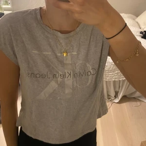 Calvin Klein tshirt - Grå/silvrig Calvin Klein tshirt, använd ett fåtal gånger så fortfarande i bra skick! 💞