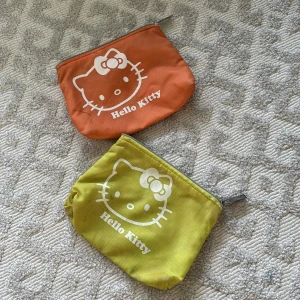 2 st Hello Kitty necessärer - 2 st små söta Hello Kitty necessärer i ljusgrön och orange säljs ihop. Lite smutsiga men går tvätta. Annars sjukt söta. 