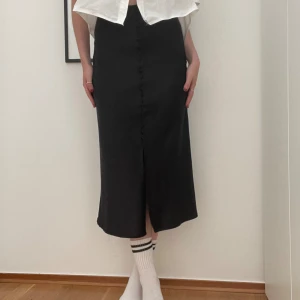 Svarta midikjol  - Supersöt svart midikjol i satin liknande material från Gina Tricot 