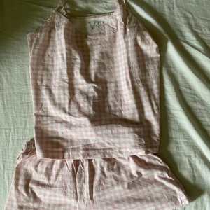 Pyjamas - En supersöt vit och rosa rutig pyjamas i nyskick med fina spetsdetaljer och rosett på shortsen. Köpte från Zalando nyligen men är tyvärr för liten för mig (jag är 162) Den är från märket Lascana, nypris 200kr säljer för 150kr!
