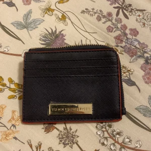 Tommy hilfiger plånbok - Helt ny oanvänd plånbok från Tommy Hilfiger i sån snygg färg combo med Röd svart och plasten är fortfarande på eftersom den är helt ny original pris 650kr  kontakta via mer frågor💯👍