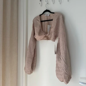 Croppad topp - En croppad långärmad topp från NA-KD i storlek 36. Aldrig använd och med prislapp kvar. 
