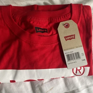Röd Levis t-shirt  - En röd Levi’s t-shirt som är oanvänd i storlek 164cm