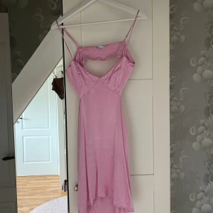 En festlig rosa klänning  - En festlig rosa klänning från bershka. Klänningen är ganska kort, öppen i ryggen och är öppet under brösten. 