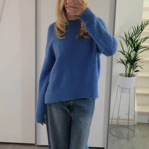 Blå stickad tröja från Zara - Sweatshirt från Zara med en fin klarblå färg. Stickad med fluffigt material och har långa ärmar. Snygg passform med slit i sidorna.  Hör av dig om du har frågor!