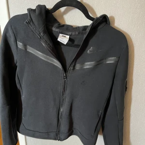 Nike tech fleece. -  Snygg svart Nike tech flis i okej skick . Defekt förekom därmed priset 450 kr För fler bilder skriv priv.
