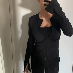 Tröja med dragkedja  - Tröja med dragkedja och slits vid händerna