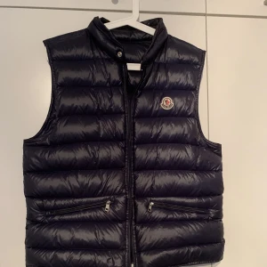 Moncler Gui Väst Size L - Moncler Gui Väst Storlek L. Den är näst intill nyskick. Moncler dustsbag tillkommer också👍🏼Mera bilder finns. Hör av dig om du har några frågor :)