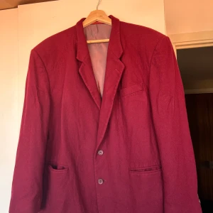 Röd oversized kavaj - Kavajen är i ull, står ingen storlek men gissar på M. Cool och snygg, köpt på second hand! 