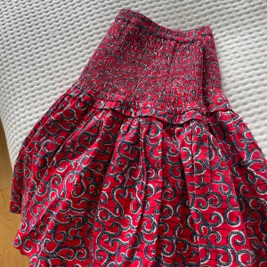 Röd kjol - Jättefin röd kjol med blått mönster, köpt på pepejeans för fyra år sedan. Nypris 600kr, inga defekter, använd fåtal gånger, så gott som nyskick. 