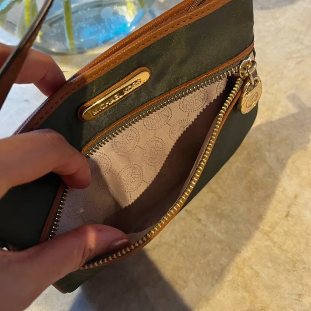 Just enough room for ID , cards & phone What more do you need?  Khaki green nylon trimmed in genuine leather & leather strap. The bag can be worn in 2 different ways.  It’s unused. Closure: zip Lining material: fabric. Väskor.