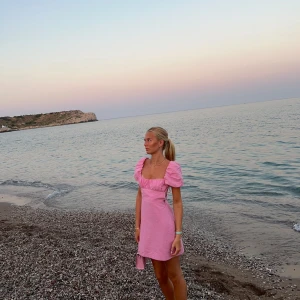 Zara Rosa klänning med puffärm och öppen rygg  - Säljer denna rosa klänningen från zara som har en kort puffärm med öppen rygg med snörning. Den är i linne aktigt tyg och i väldigt fint skick då den endast är använd 2 gånger! Storlek s och säljer för 250kr 