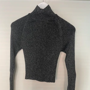 Glittrig tröja - Glittrig tröja ifrån Gina Tricot i storlek xs. Fint skick, knappt använd. Lite öppen i ryggen (se bild) 
