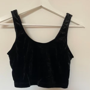 Svart croptop  - Svart croptop i sammet från Bikbok, storlek XS. Är i ungefär samma längd som en sport-BH, så väldigt croppad