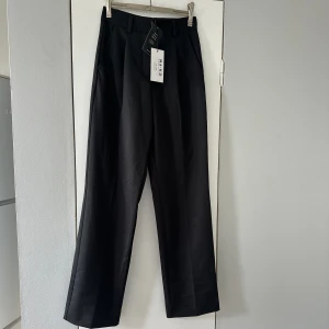 HELT NYA kostymbyxor - Helt nya kostymbyxor från nakd i storlek 32 men sitter som en 34 då de både är långa i benen samt stretchiga! Min favoritmodell på kostymbyxor men dessa blev tyvärr för små innan jag hann använda dem därav att de säljs. 