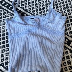 Cute ny croptopp - Helt ny. Aldrig använt. Ljusblå och med spets. Jätte gulligt och ganska kort. Med justeringsband. 