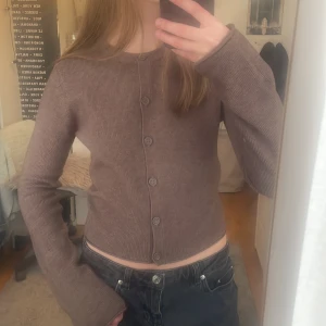 Brun stickad tröja - Brun stickad tröja med knappar. Lite croppad och kortare i modellen. 