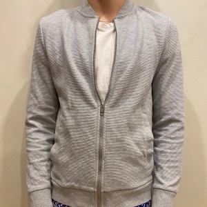 Tröja H&M - Tröja H&M  Modell: 184cm & väger 84kg  Skick: allmänt använd Färg: Grå Material: polyester, bomull 