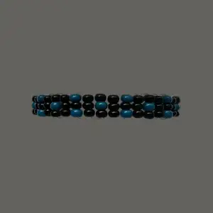 Poseidon II är ett snyggt armband uppbyggt av blå och svarta rocaillespärlor. Armbandet har en omkrets på cirka 18 cm men är töjbart.
