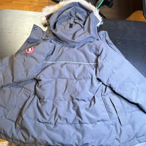 Canada Goose Jacket  - Äkta Canada Goose från canadagoose.com. Använd och  i  okej skick (finns några skador). Har riktigt päls på luvan. Säljer för att jag har växt ut den. Jackans värme gör den perfekt för kalt väder. 