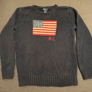 Ralph Lauren Flag Knit Tröja - En stickad Ralph Lauren tröja i bra skicka. Den är i barnstorleken XL, skulle väl säga att det motsvarar en XS-S.
