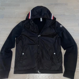 Moncler windbreaker - || Fet Moncler windbreaker/cardigan || Givetvis Äkta || 10/10 skick förutom ett litet ”bränn” hål på framsidan där av priset, men som knappt syns (hör av er för närmare bilder || Stilren med en väldigt fin luva med moncler färgerna som ränder || Hör av er vid frågor ||
