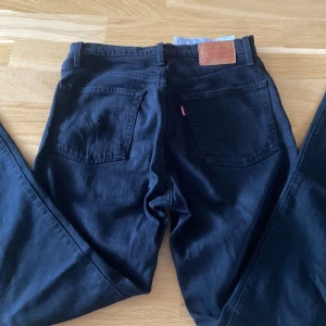 Levis Jeans 501 - Höjmidjade svarta jenas från Levis. Köpta några år sen och är knappt använda. Mycket bra skick. Nypris 1250kr säljer för 500. Pris kan diskuteras. Skriv för fler frågor eller bilder. Storlek W26 L30