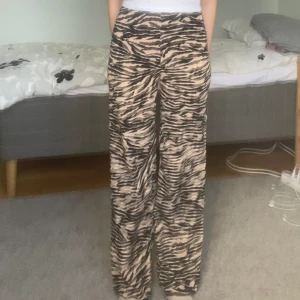 Djurmönstrade byxor - Trendiga tigermönstrade byxor. Midjemåttet är 30 cm, innerbensmåttet är 75 cm och höftmåttet är ca 40-45 cm. Om du undrar något är det bara att fråga. 