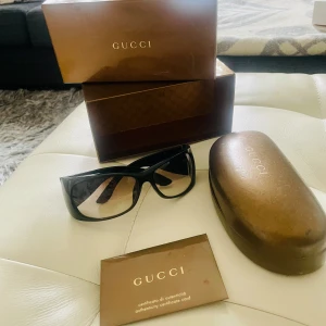 Gucci svarta tonade solglasögon  - Gucci solglasögon  Färg:svart halvtonade glas Använda men i gott skick inga repor  Fodral i sammet något slitet men bra skick. 