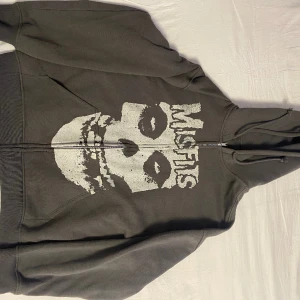 Misfits Zip Up - En mörk grå misfits zip up hoodie, oversized med fluffig insida. Sitter fint på kroppen och är i bra skick! 🖤